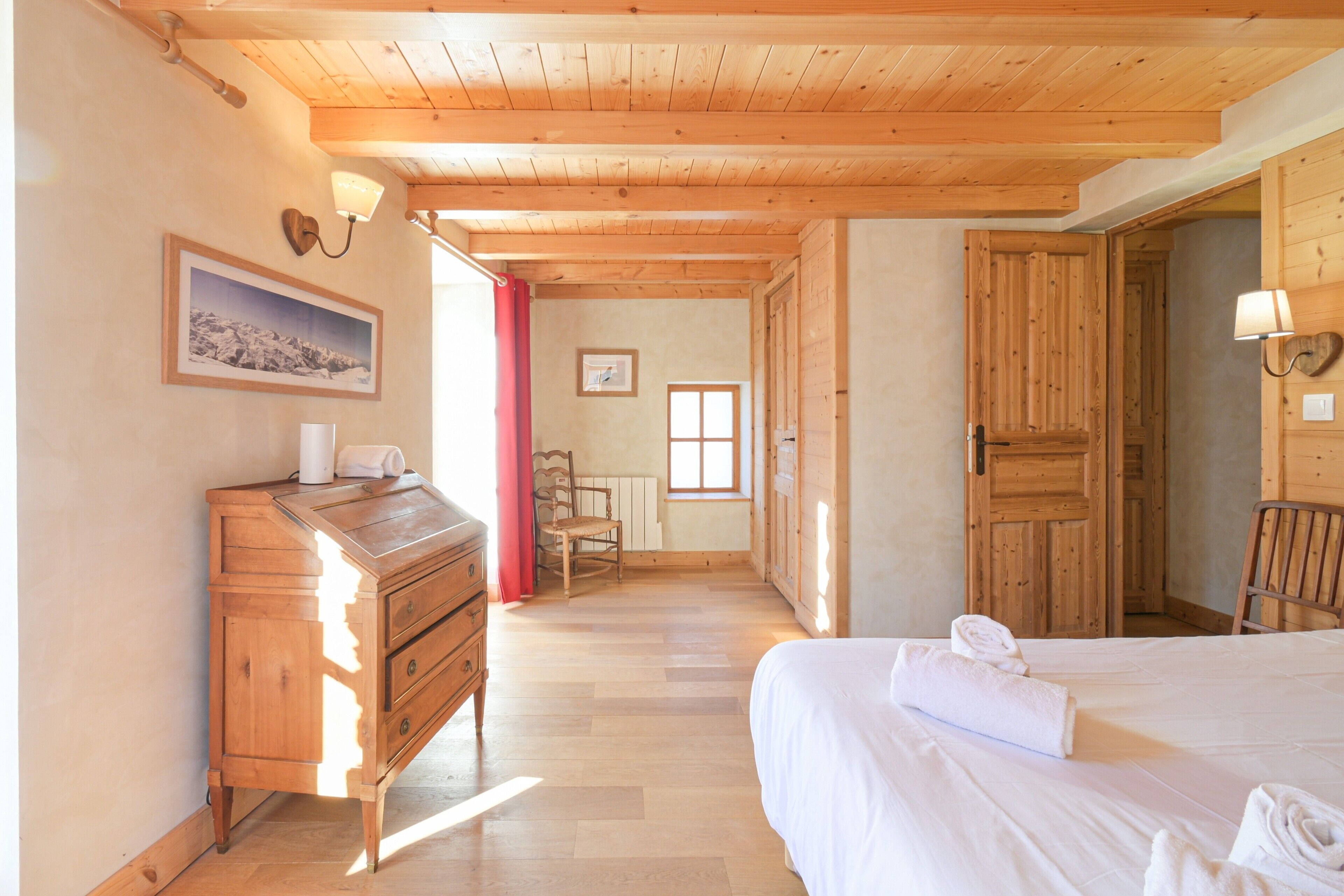 Ein Zimmer mit Holzwänden, einem Bett, einem Schminktisch und einem Stuhl.