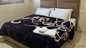 Une chambre à coucher avec un lit, une tête de lit, une fenêtre et une lampe de sol.