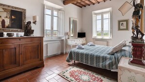 Ein Schlafzimmer mit Bett, Schminktisch und Kunstwerken.