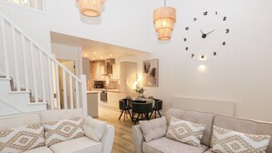 A modern living room with two sofas, a dining table, and a kitchen in the background. - Loco Lodge (Keighley)