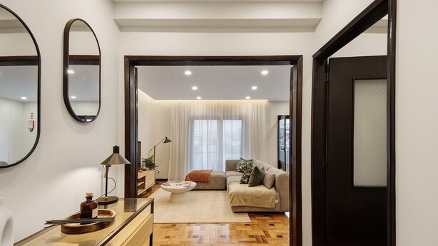 A modern living room with a sofa, a coffee table, and a mirror on the wall. - Apartment 'Station 54' with Balcony and Wi-Fi (Porto)