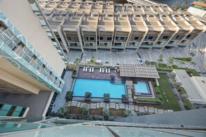 A high-rise building with multiple balconies, a rooftop pool, and a view of the surrounding area. - 1011 Bloomfields1BR Al Nada Raha Beach (Madinat Zayed)
