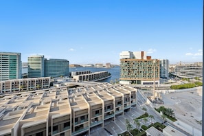 A modern urban area with a marina, high-rise buildings, and a parking structure. - 1011 Bloomfields1BR Al Nada Raha Beach  (Madinat Zayed)