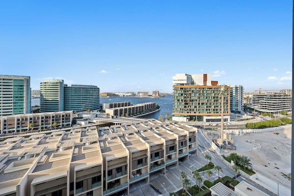 A modern urban area with a marina, high-rise buildings, and a parking structure. - 1011 Bloomfields1BR Al Nada Raha Beach (Madinat Zayed)