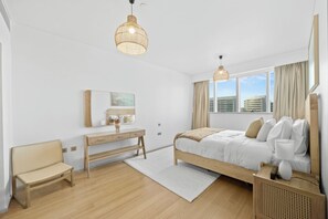 A modern hotel room with a bed, bedside table, chair, and large windows. - 1011 Bloomfields1BR Al Nada Raha Beach (Madinat Zayed)
