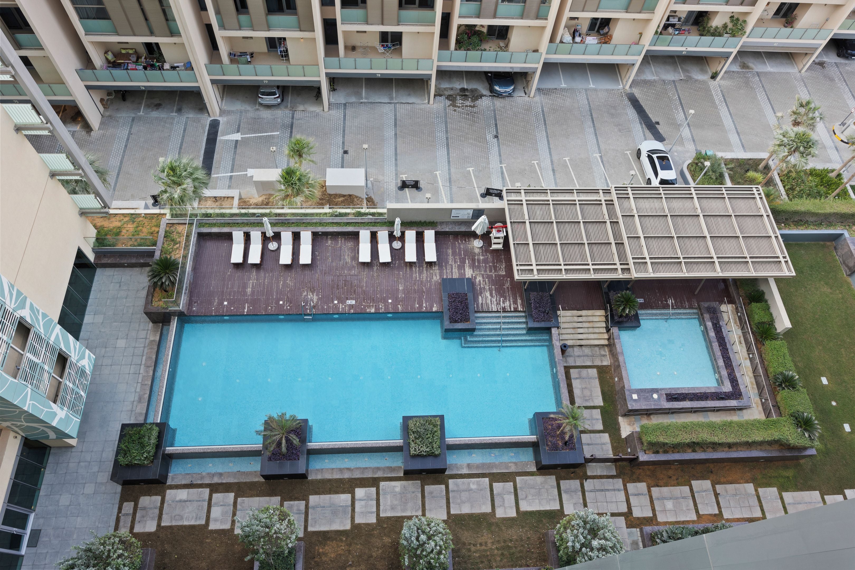 A rooftop swimming pool with lounge chairs and a small adjacent pool.