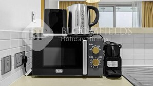 Keittiössä on Black+Decker-merkkinen mikroaaltouuni, kahvinkeitin ja vedenkeitin.