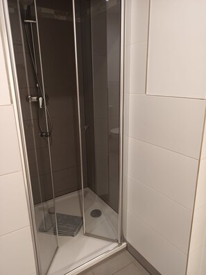 Een douche, een bubbelbad, een bidet, handdoeken