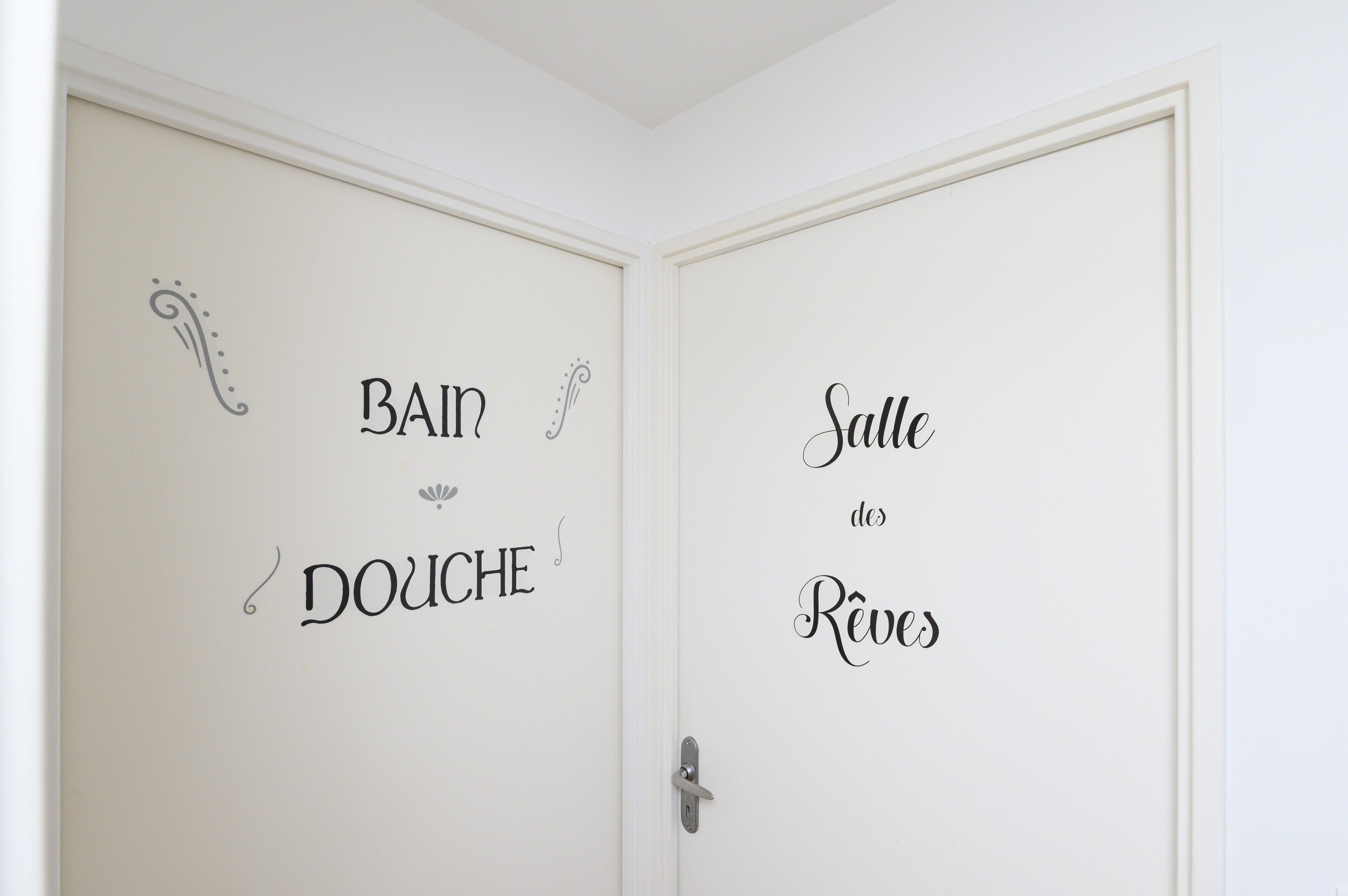 A door with French text indicating 'Bain Douche' and 'Salle des Réveils'.
