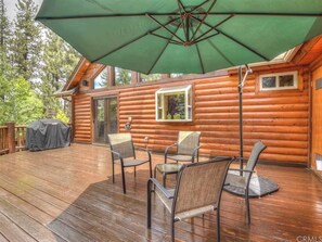 Une cabane en bois dotée d’une terrasse, d’un espace salon extérieur et d’un patio couvert.