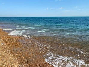 A pebbled beach with clear water and a calm sea. - Rural barn conversion in beautiful countryside (Stelling Minnis)