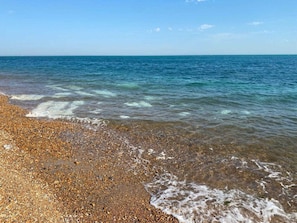 A pebbled beach with clear water and a calm sea. - Goose Shed | Rural Farm Cottage | Cosy Fire (Stelling Minnis)