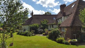 A traditional brick house with a sloped roof, a well-maintained garden, and a clear sky. - Goose Shed | Rural Farm Cottage | Cosy Fire (Stelling Minnis)