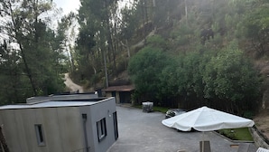 Une piscine avec une terrasse en bois, des chaises longues et un parasol blanc.