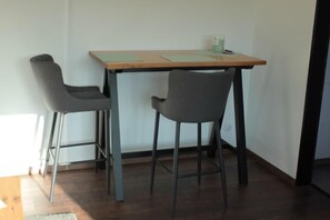 Ein kleiner Essbereich mit einem Holztisch und zwei grauen Stühlen.