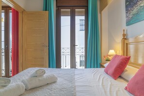 Une chambre d’hôtel avec un lit, une table de chevet, une lampe et une vue sur l’extérieur.