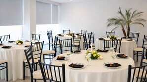 A spacious dining area with round tables, black chairs, and white tablecloths. - Hotel Lois Express Monterrey Aeropuerto La Fe (Apodaca)