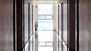 A long, narrow hallway with a reflective floor leading to a bright exit door. - Hotel Lois Express Monterrey Aeropuerto La Fe (Apodaca)