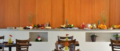 A modern dining area with wooden paneling, a fruit display, and a clean, contemporary design.