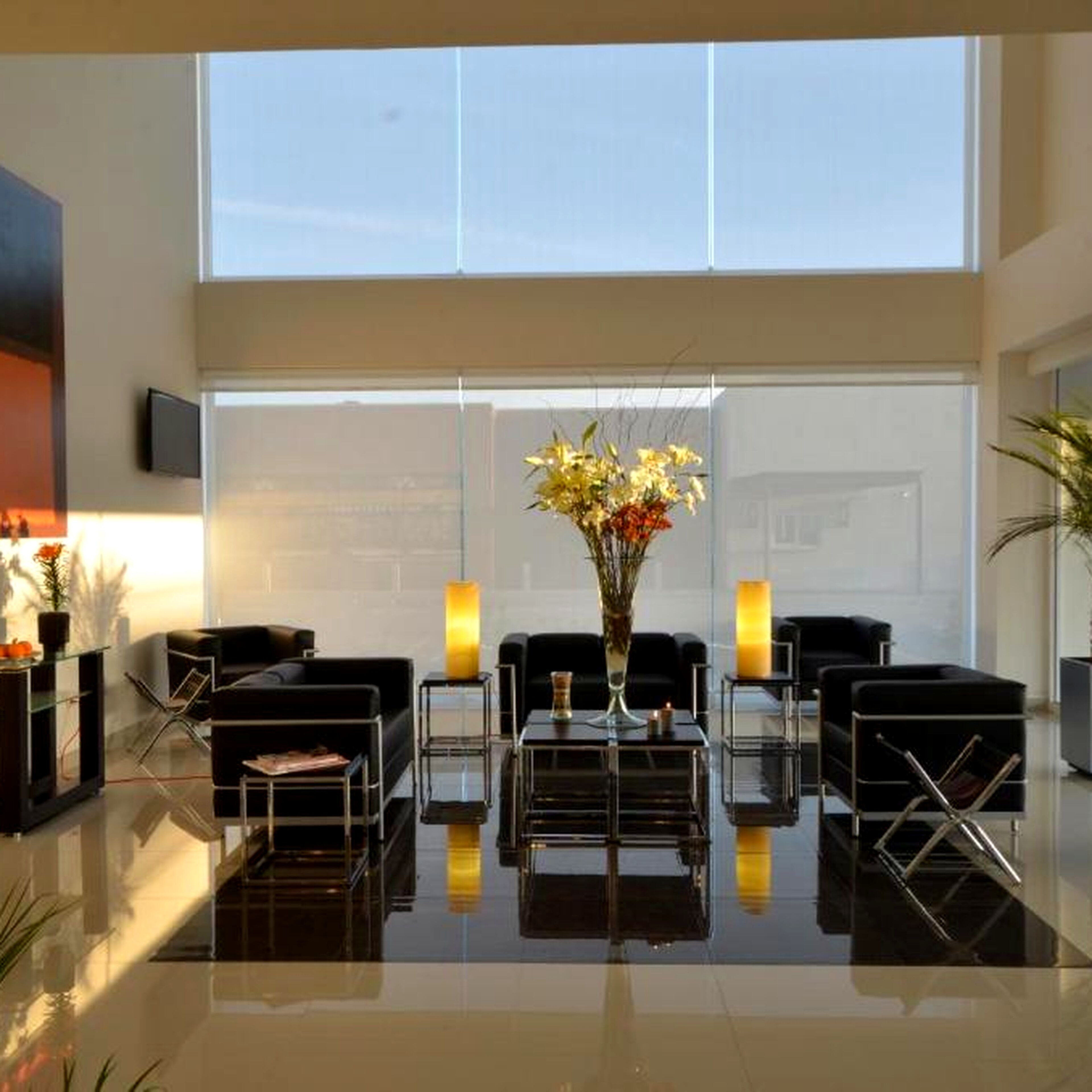 A modern lobby with a reception desk, seating area, and large windows.