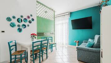 Leilighet – deluxe, havutsikt, ved strandkanten | Oppholdsområde | En 40-tommers smart-TV med digitale kanaler samt PC-skjermer og printere