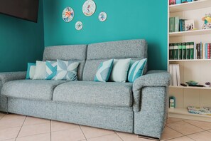 Departamento Deluxe, vista al océano, frente al mar | Área de sala de estar | Smart TV de 40 pulgadas con canales digitales y monitor de computadora 