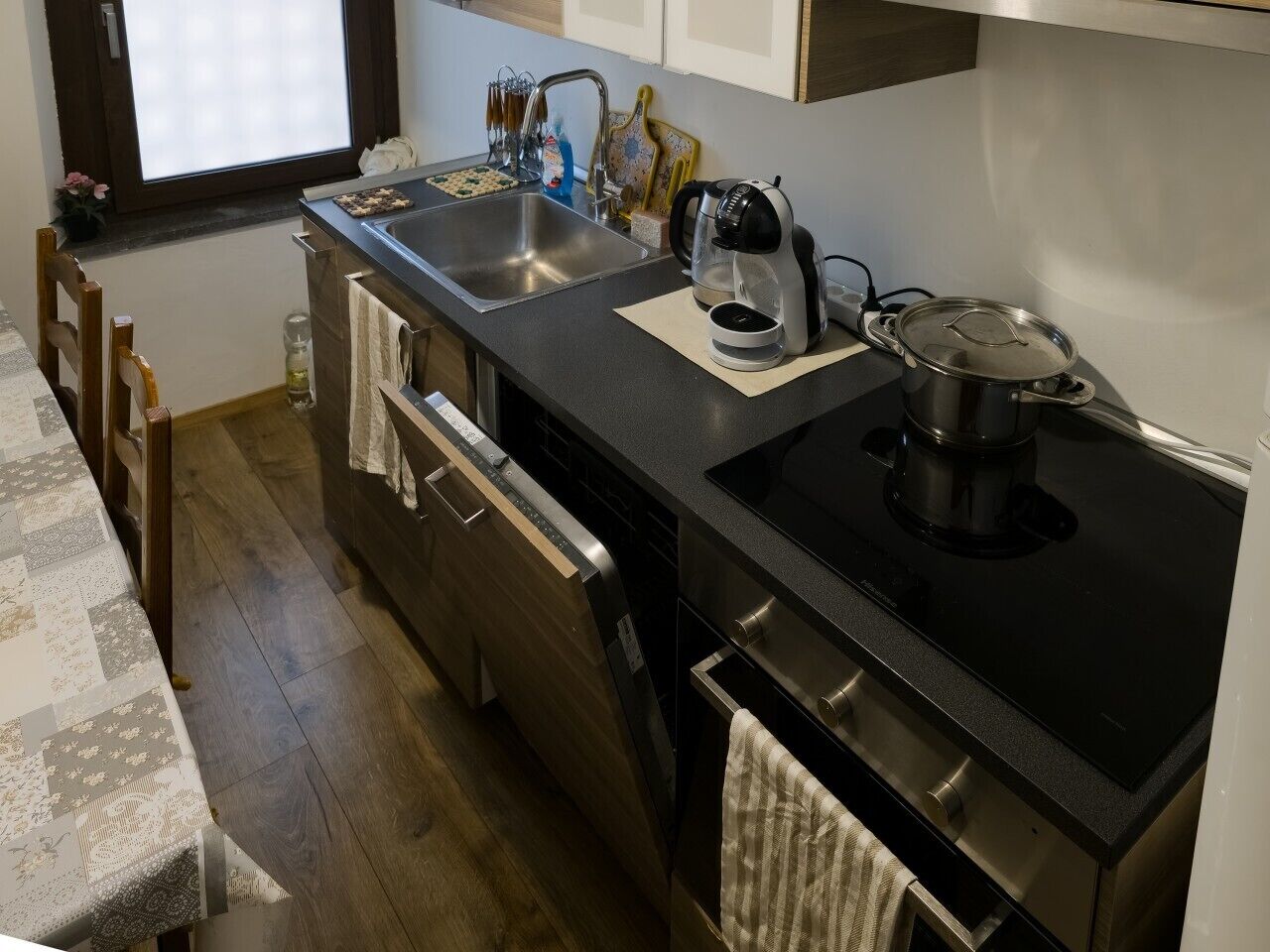 A compact kitchen with a sink, stove, and dishwasher.