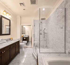 A modern bathroom with a marble shower, a bathtub, and a vanity with a mirror and sink. - Madison I by StayHaus | Full-floor Flatiron 2BR (New York)