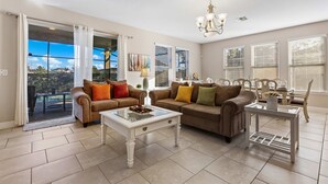 A spacious living room with two sofas, a coffee table, and a dining area with a table and chairs. - 4163 Oak Tree Drive (Davenport)