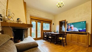 Un accogliente soggiorno con camino, zona pranzo e televisione.
