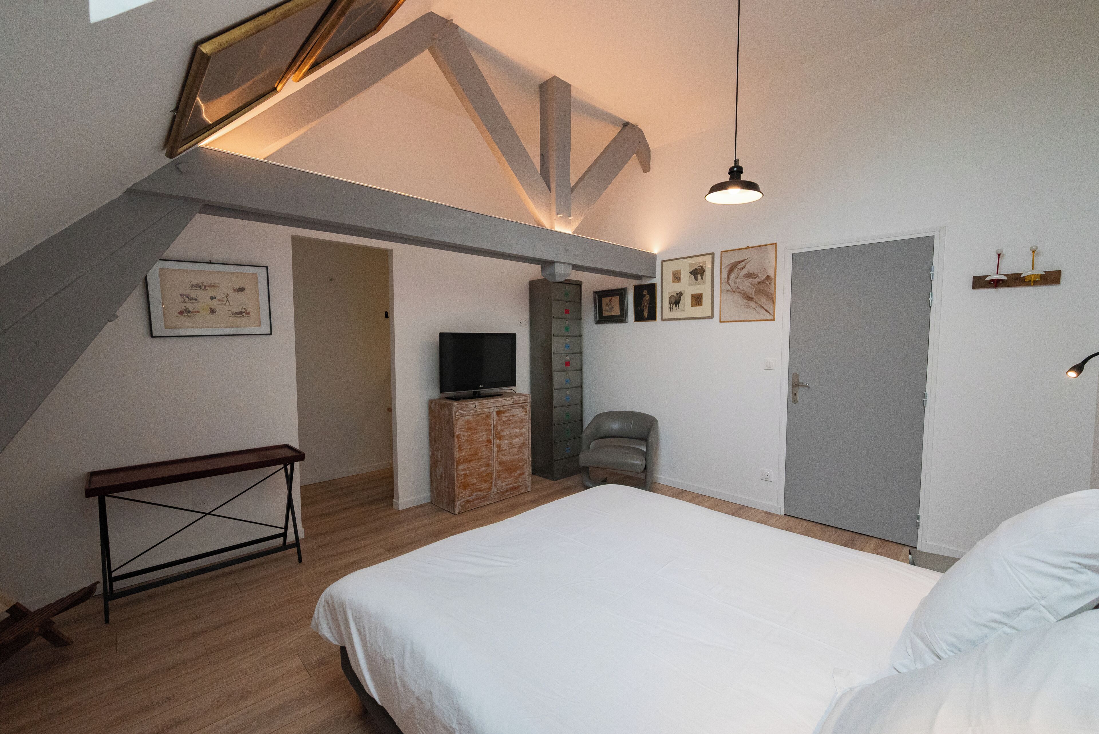Une chambre à coucher avec un lit, une télévision, un bureau et une chaise.