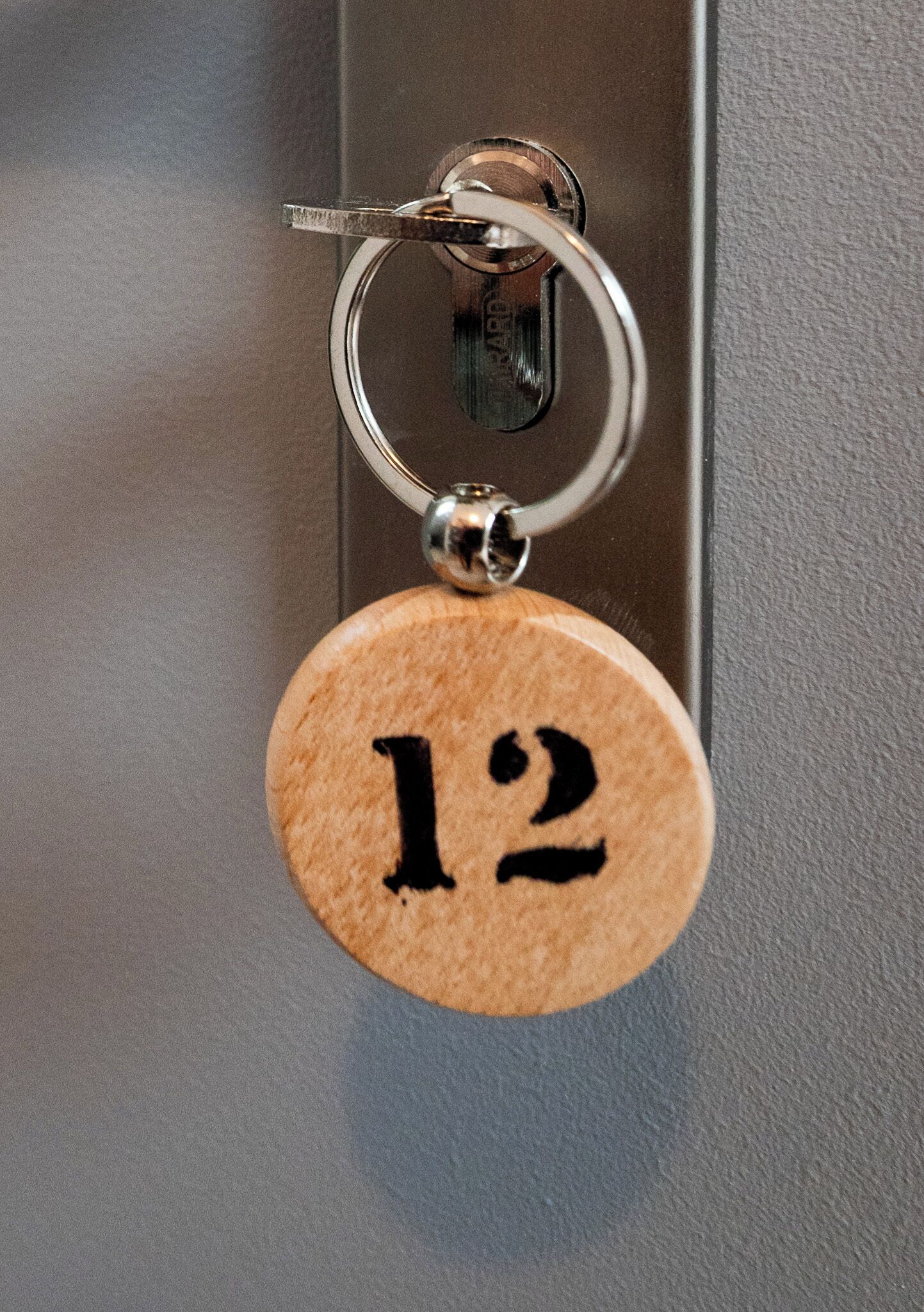 A keychain with the number '12' attached to a door handle.