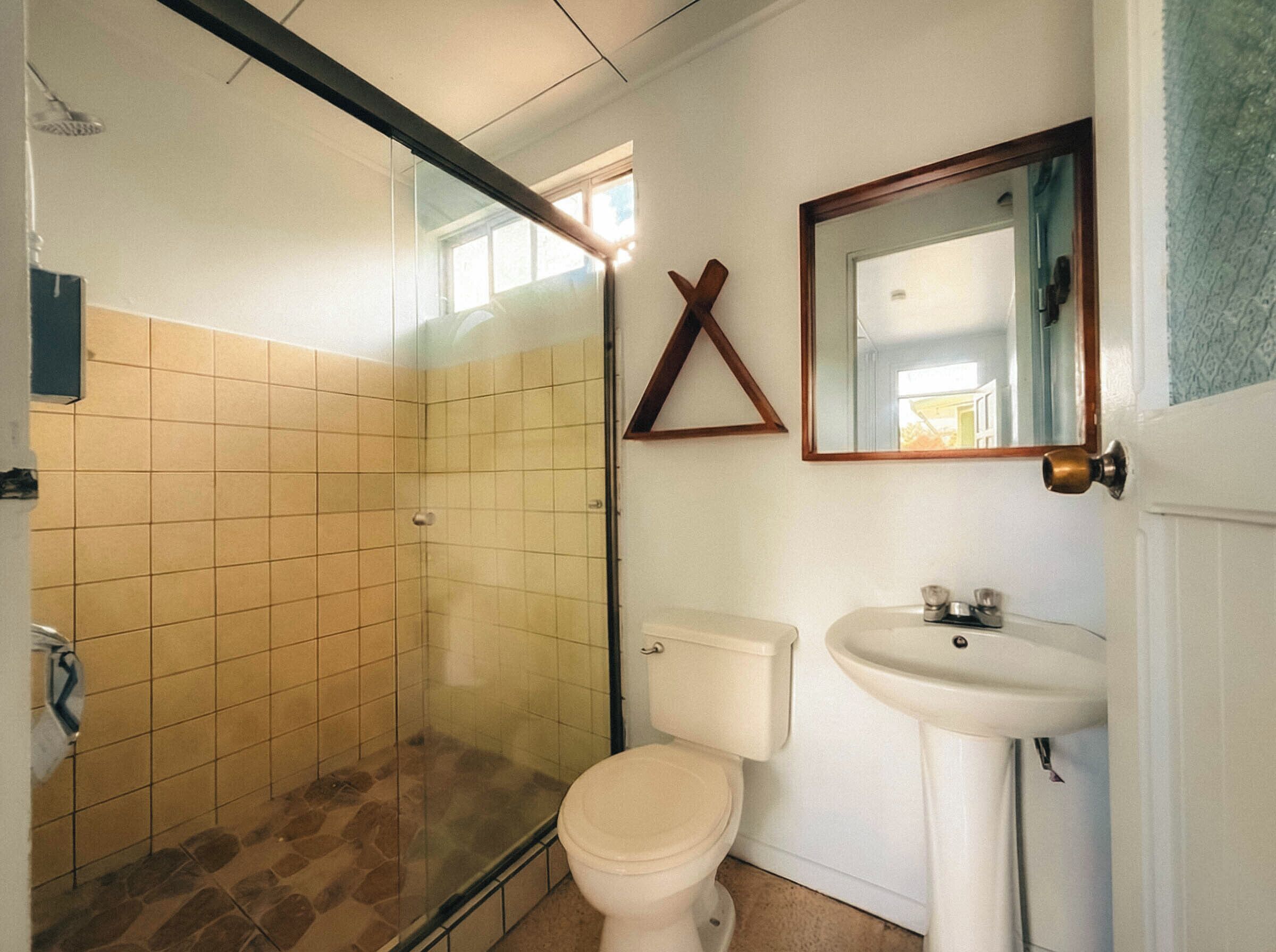 Un baño con cabina de ducha de vidrio, inodoro y lavabo.