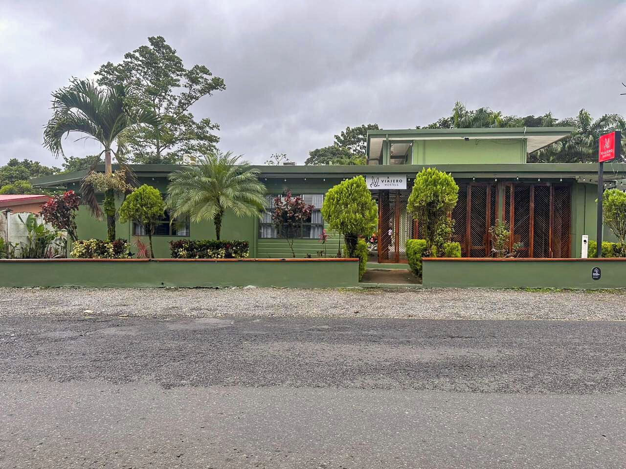 Un bâtiment vert avec une enseigne indiquant « VIAJERO HOSTELS ».