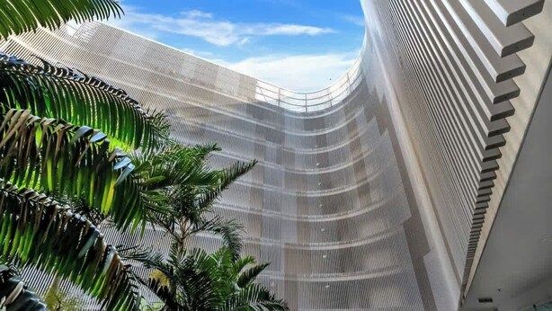 A modern building with a curved facade and a series of vertical lines. - Marina Vista—Waterfront Stay near Dining & Markets (Cairns)