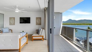 A balcony with a view of a body of water and mountains. - Marina Vista—Waterfront Stay near Dining & Markets (Cairns)