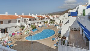 Ein Resort mit Schwimmbad, Liegestühlen und einer Bergkulisse.
