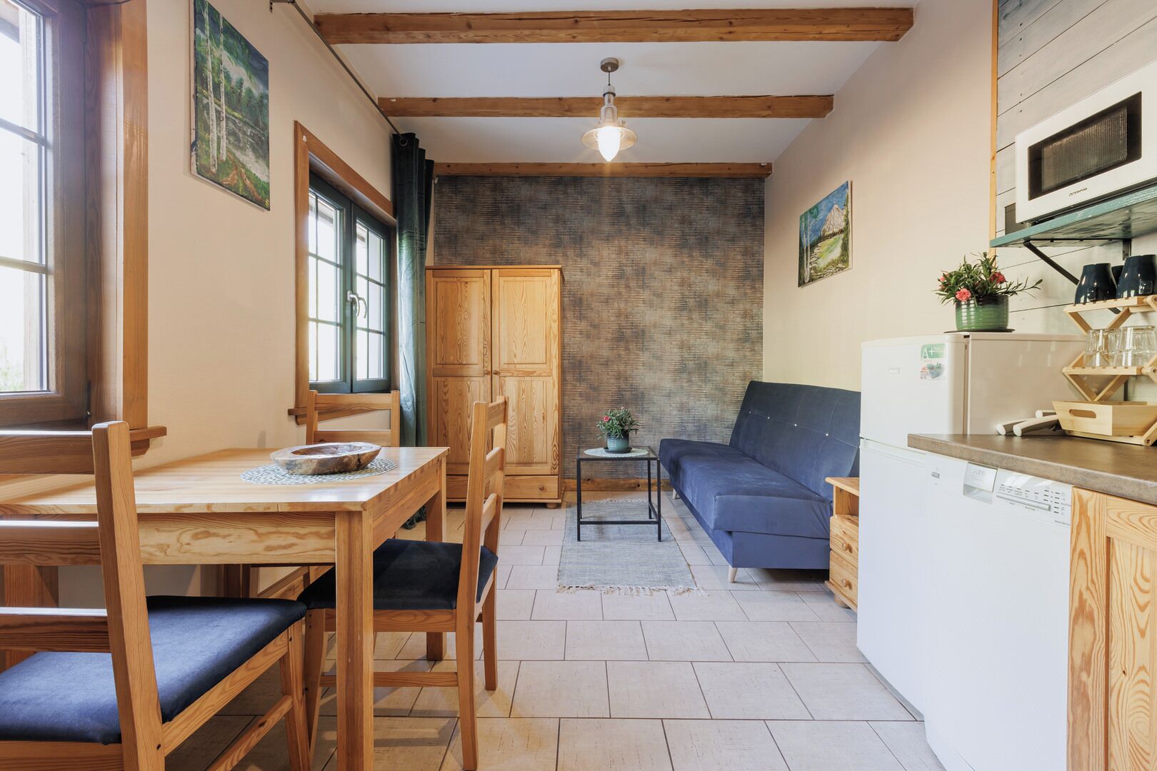 Un espacio habitable compacto con comedor, sofá y kitchenette.