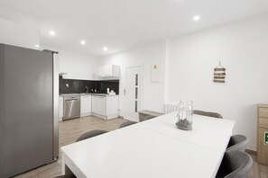 A modern kitchen with white cabinets, a stainless steel refrigerator, and a dishwasher. - Maison d'hôtes dos Limites - Espinho (Espinho)