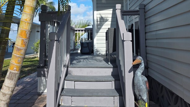 A wooden staircase leading to a house with a 'WELCOME' sign at the bottom. - Waterfront Dream Home in Bradenton Full of Amenities (Bradenton)