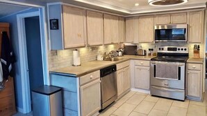 A modern kitchen with white cabinets, stainless steel appliances, and a central island. - Waterfront Dream Home in Bradenton Full of Amenities (Bradenton)