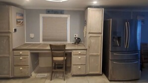 A kitchen with a built-in desk, a refrigerator, and a ceiling fan. - Waterfront Dream Home in Bradenton Full of Amenities (Bradenton)
