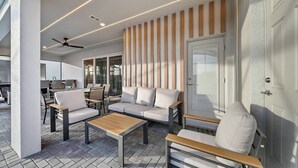 Een moderne buitenzitplaats met een bank, stoelen en een tafel.