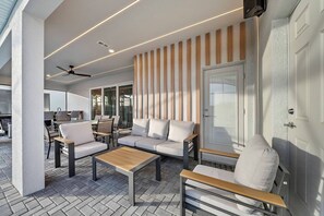 Eine moderne Außenbereich-Sitzgruppe mit einer Couch, Stühlen und einem Tisch.