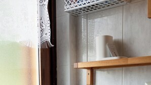 A front-loading washing machine in a laundry room with a window, a wooden shelf, and a towel rack. - Relax in the greenery of the central Abruzzo Apennines (Cappadocia)