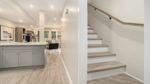 A modern kitchen with grey cabinets, a central island, and recessed lighting. - Pet-Friendly 1BR With Office & Fenced Yard (Ottawa)