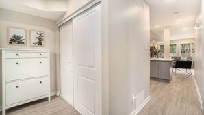 A modern kitchen with a central island, white cabinetry, and a dining area with a black chair. - Pet-Friendly 1BR With Office & Fenced Yard (Ottawa)