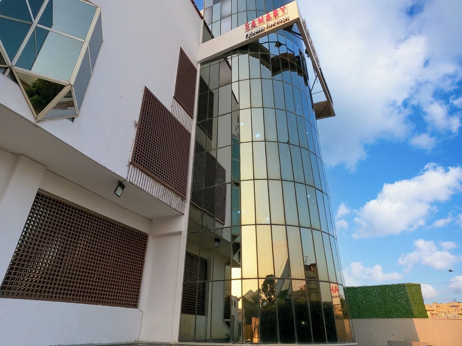 A modern building with a glass facade and a sign that reads "SAHARY".