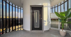 A modern building with a dark door, large windows, and a potted plant. - Sahary Pyramids View Hotel (Giza)