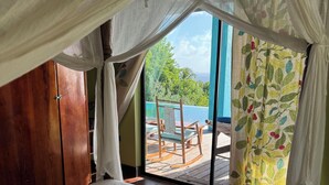 Un dormitorio con cama, armario de madera y vistas a una piscina y zona de estar al aire libre.